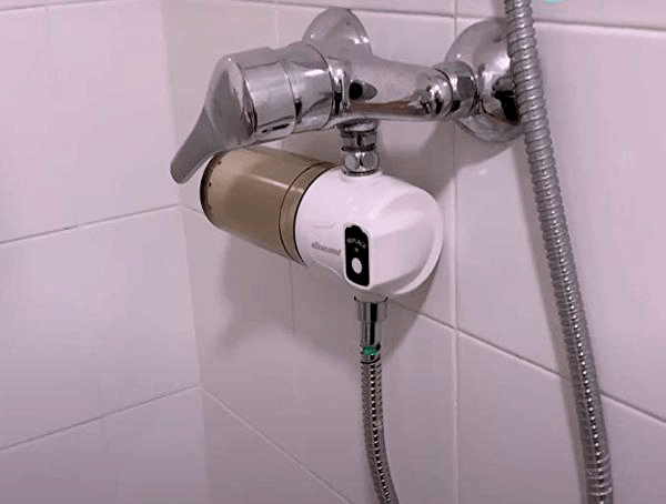 Shower filter connected to a bathtub hose in bathroom
